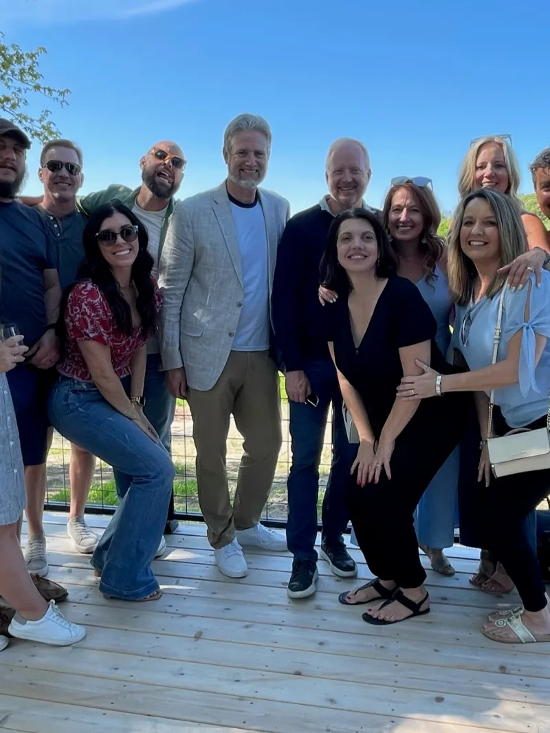 a group of people sitting on a bench posing for the camera