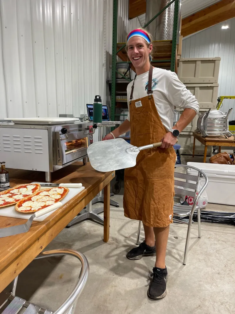 a person holding a box of pizza